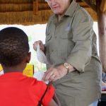 Jenny Firth hands hamper to a young learner from Diphetogo crèche.